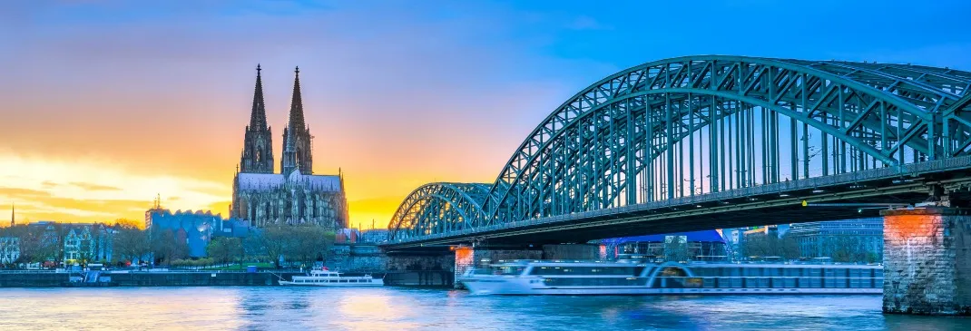 Brücke und Kölner Dom bei Sonnenuntergang.
